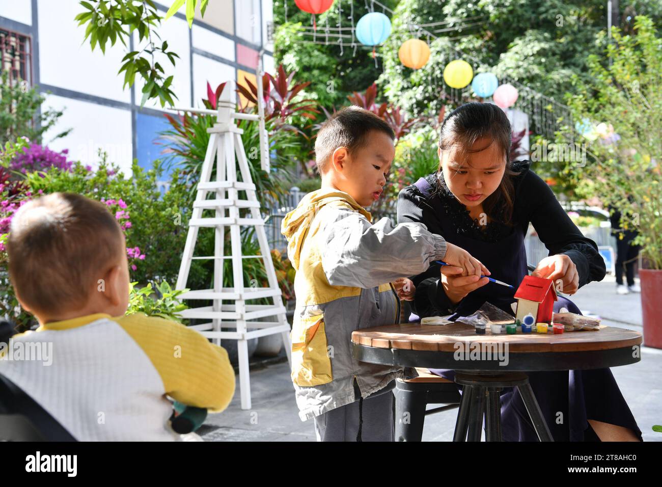 (231119) -- SHENZHEN, Nov. 19, 2023 (Xinhua) -- A mother does handwork with her child in Shangwei Village, a child-friendly arts village, in Longhua District of Shenzhen, south China's Guangdong Province, Nov. 19, 2023. Shenzhen launched China's first guidelines for building a child-friendly city eight years ago. Since then the city has been rolling out a spate of measures spearheading the construction towards this aim. Statistics shows that by October of 2023, 452 city-level child-friendly bases and over 1,260 children's parks of various categories have been set up to gradually improve chi Stock Photo