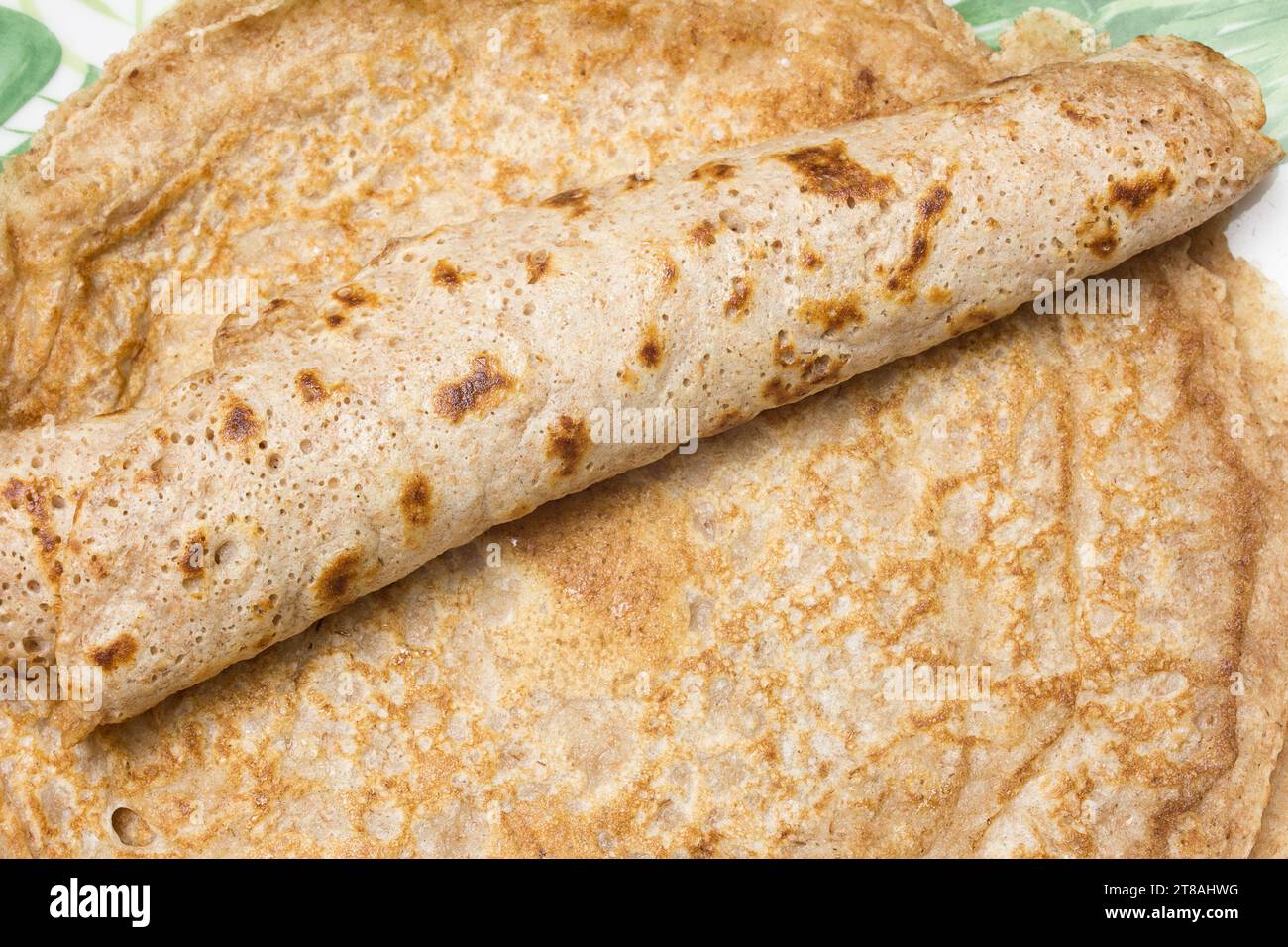 A detailed closeup showcasing a single Spanish crepe elegantly rolled