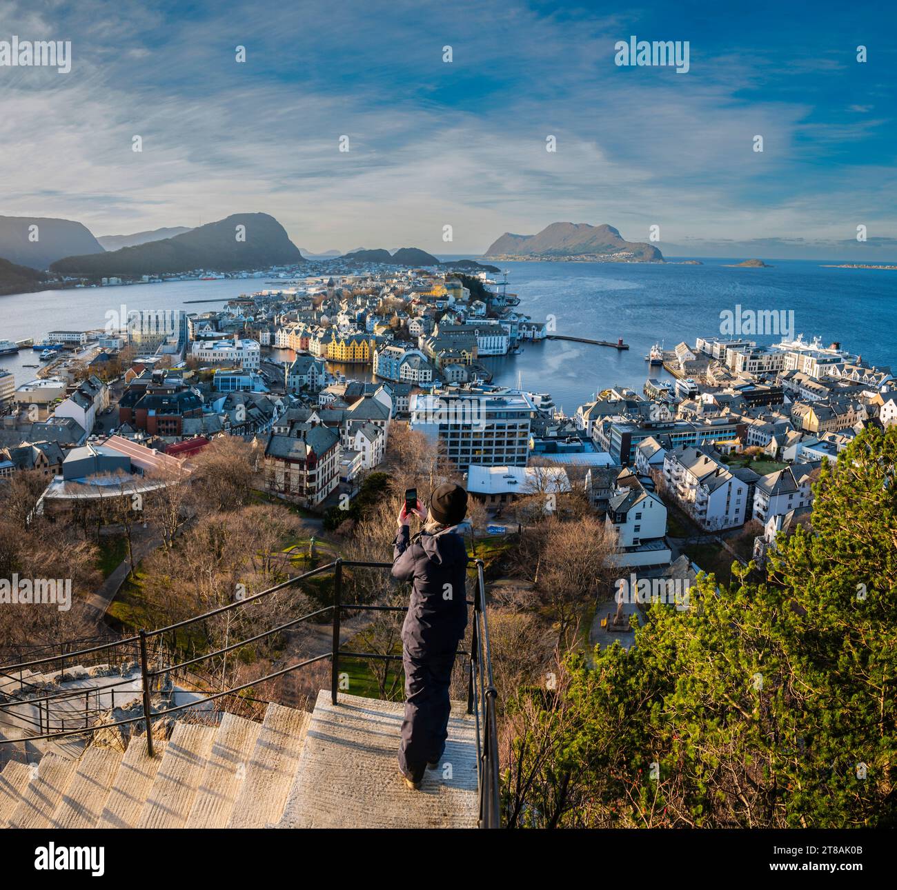 Female taking a photo from on of the 418 steps leading to Aksla Viewpoint, Alesund, More og Romsdal County, Norway. Stock Photo