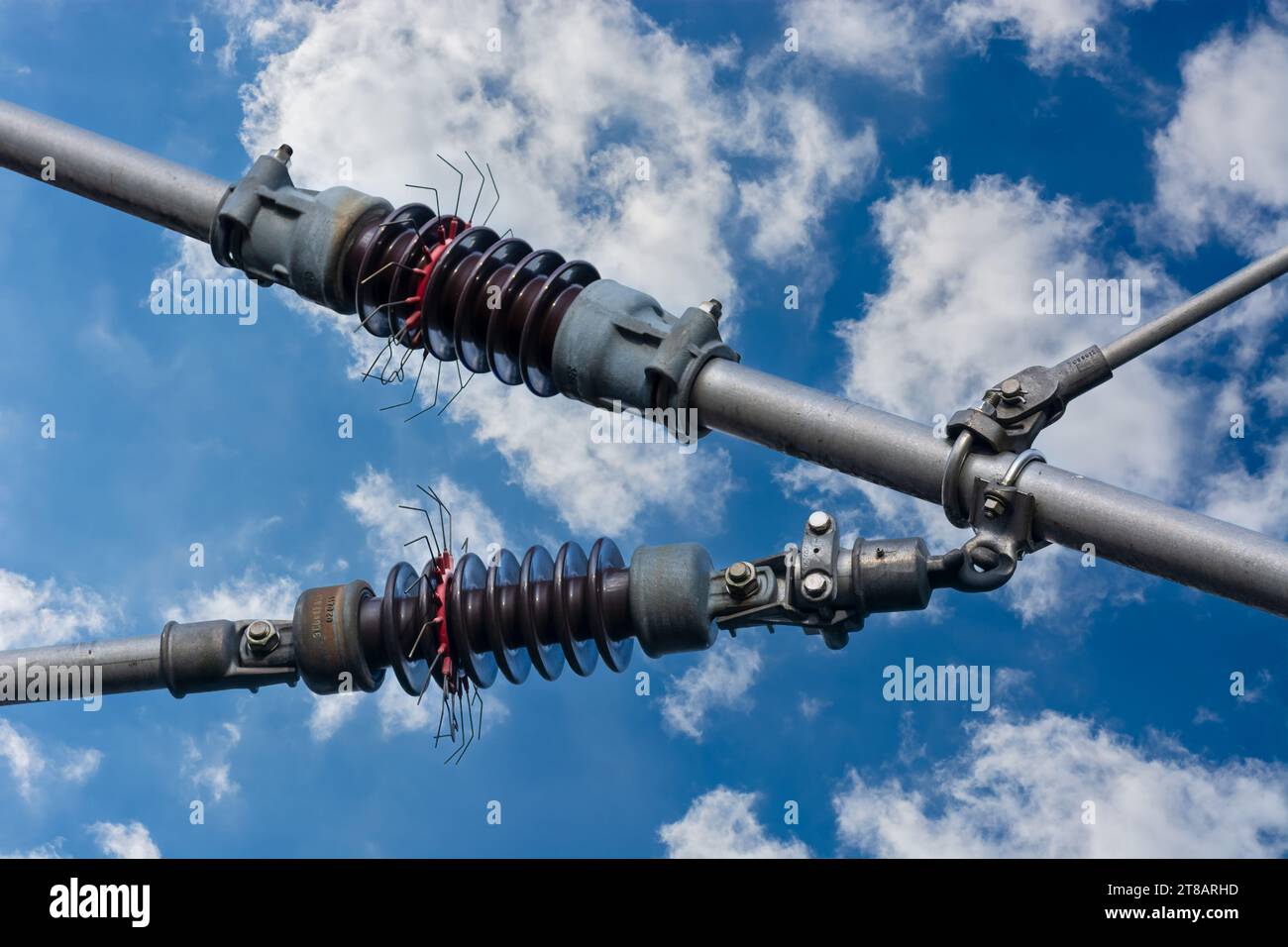 Fragment of fastening electrical wires on railway tracks against a background of blue sky. Stock Photo
