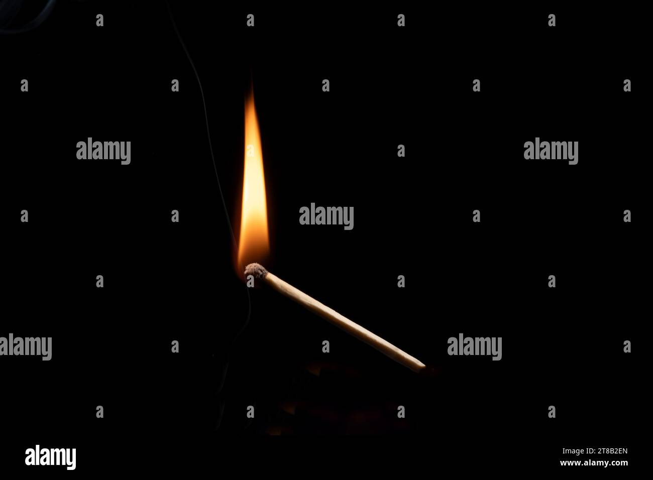 Lit and falling match on a black background. Stock Photo