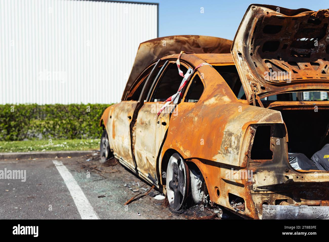 a burned-out car in the parking lot near the visa shop at the back of Stock Photo