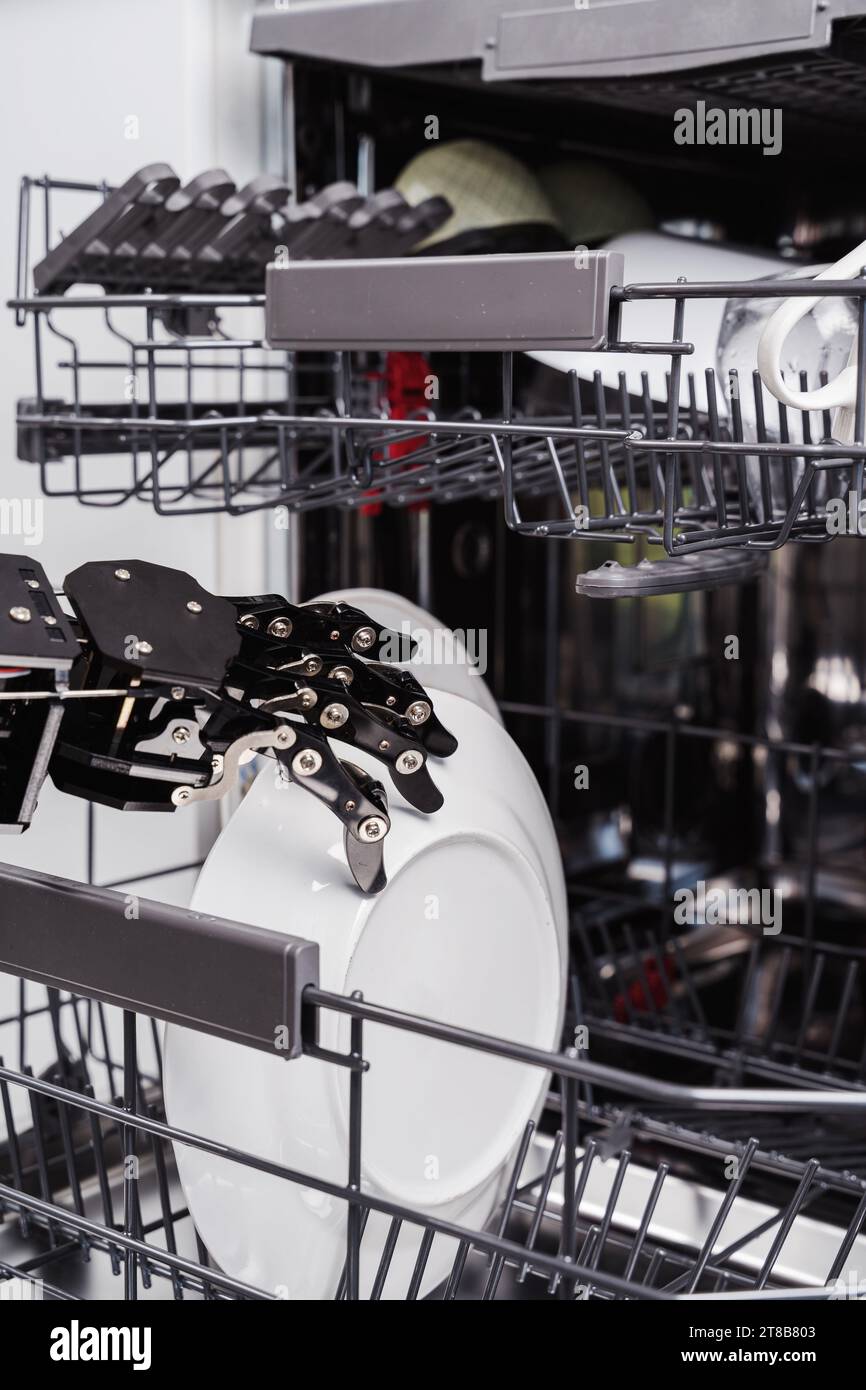 Real robot's hand and dishwasher machine. Concept of Artificial