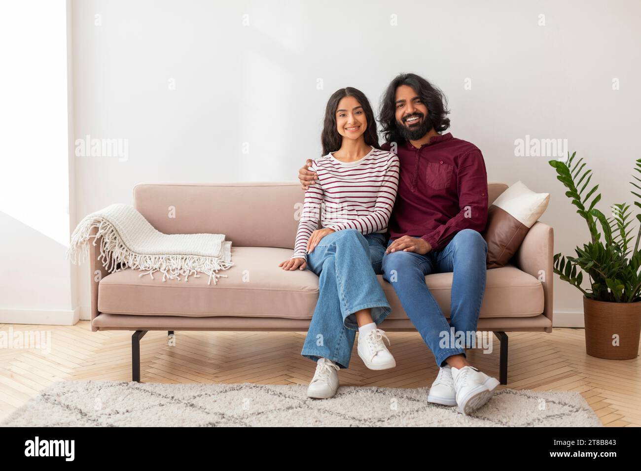 Happy millennial indian couple sitting on couch in living room Stock ...