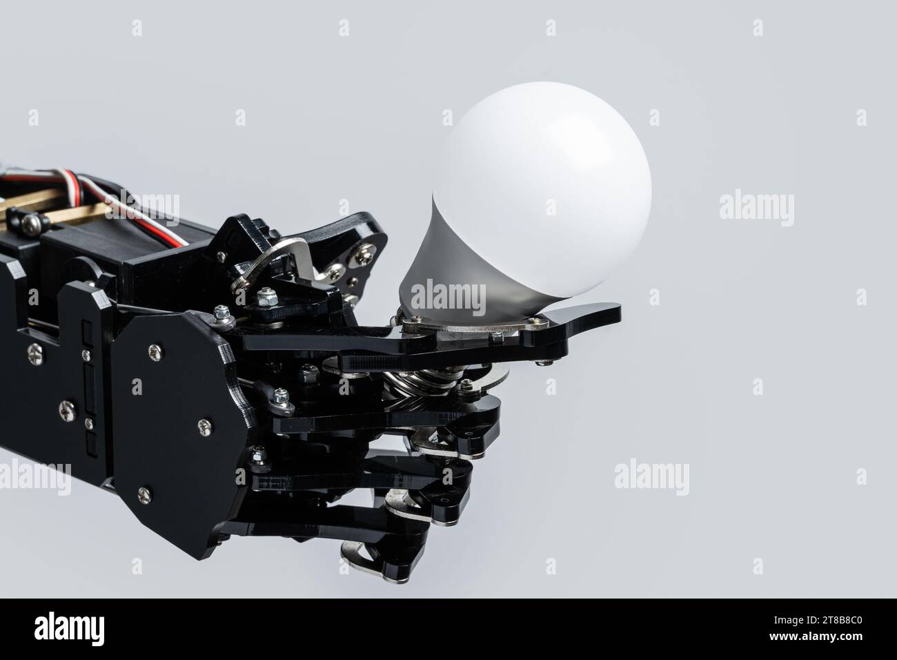 Real robot's hand holding lightbulb. Concepts of artificial intelligence development and machine learning. Stock Photo