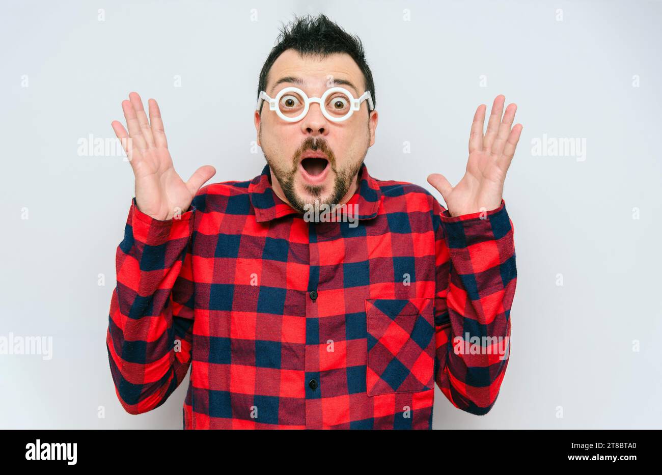 Surprised man portrait with glasses and open mouth at empty space for promotion. Wow, it's super low price, discount. Funny shocked emotion comical fa Stock Photo