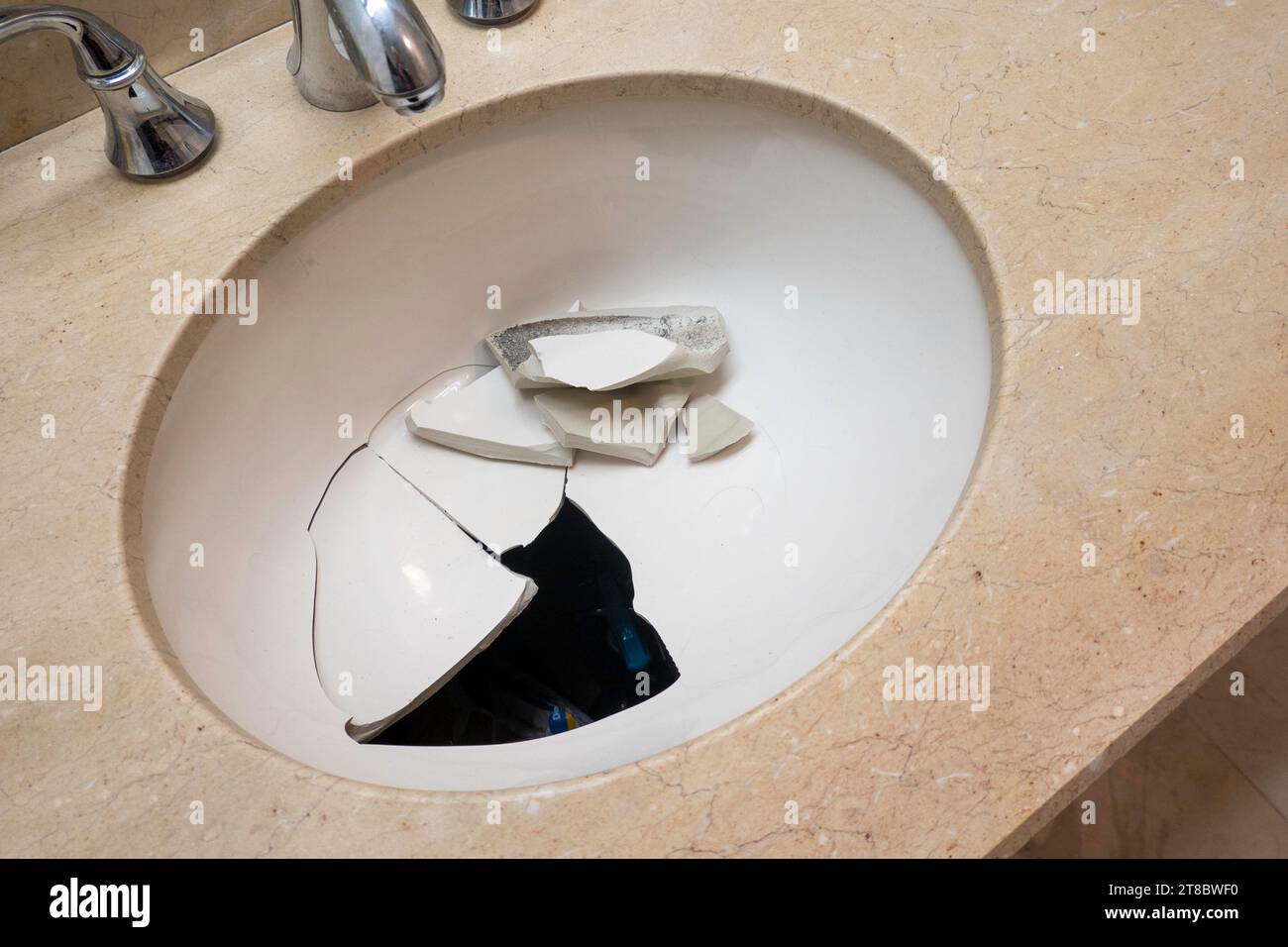 Close-up of a broken, porcelain sink, set in bathroom vanity, 2023, New York City, USA Stock Photo