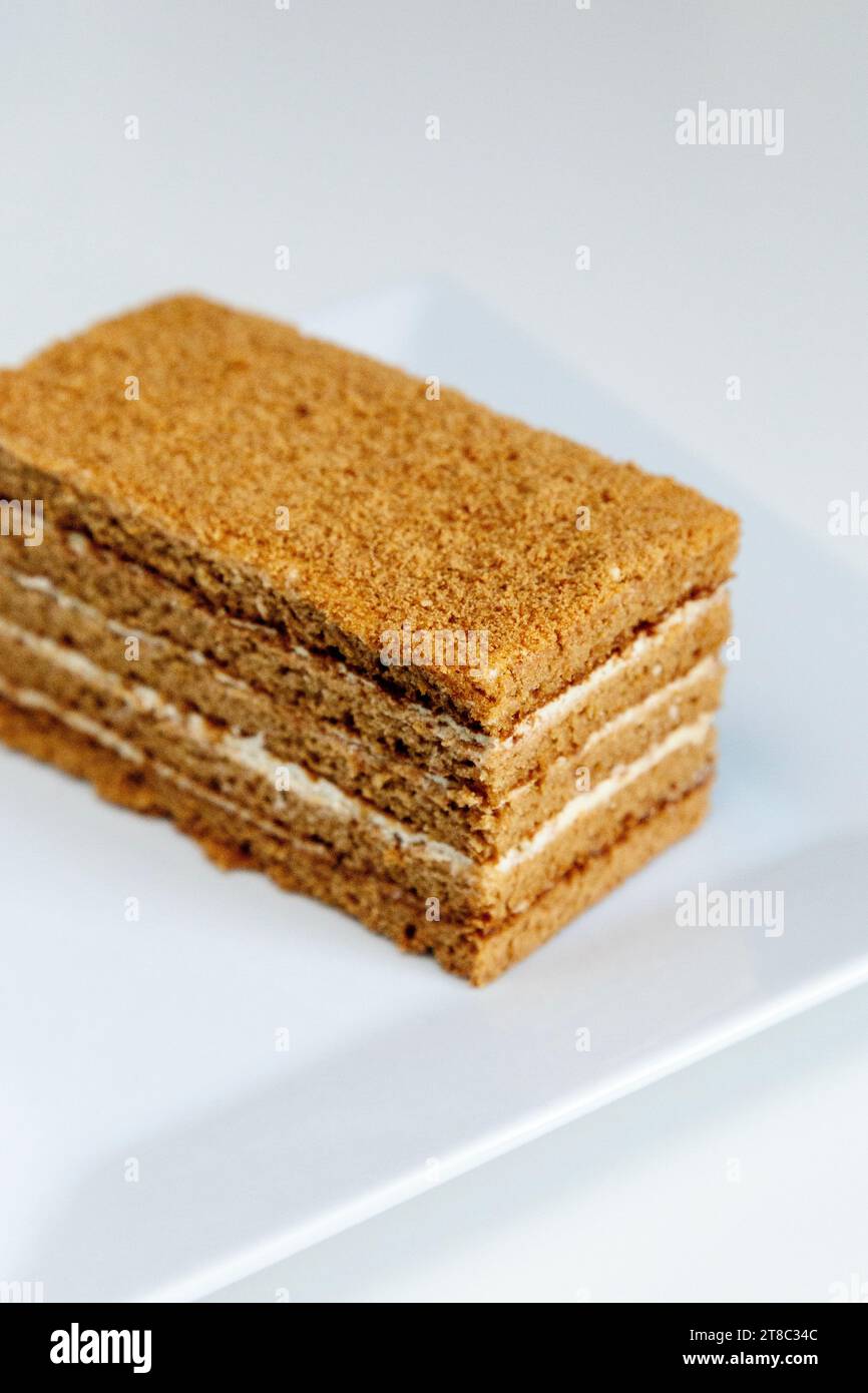 A slice of Russian honey cake (medovik) on a white plate Stock Photo