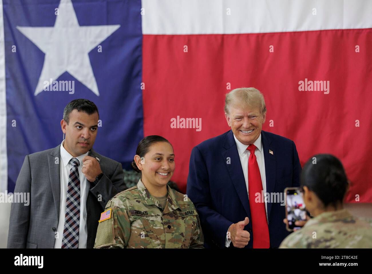 Edinburg, Texas USA, November 19 2023: Former President DONALD TRUMP, a candidate for the Republican presidential nomination, poses for a photo with a young female member of the Texas National Guard at the South Texas International Airport. Trump flew in for a campaign rally at the airport. Photo by Michael Gonzalez/Pool Stock Photo