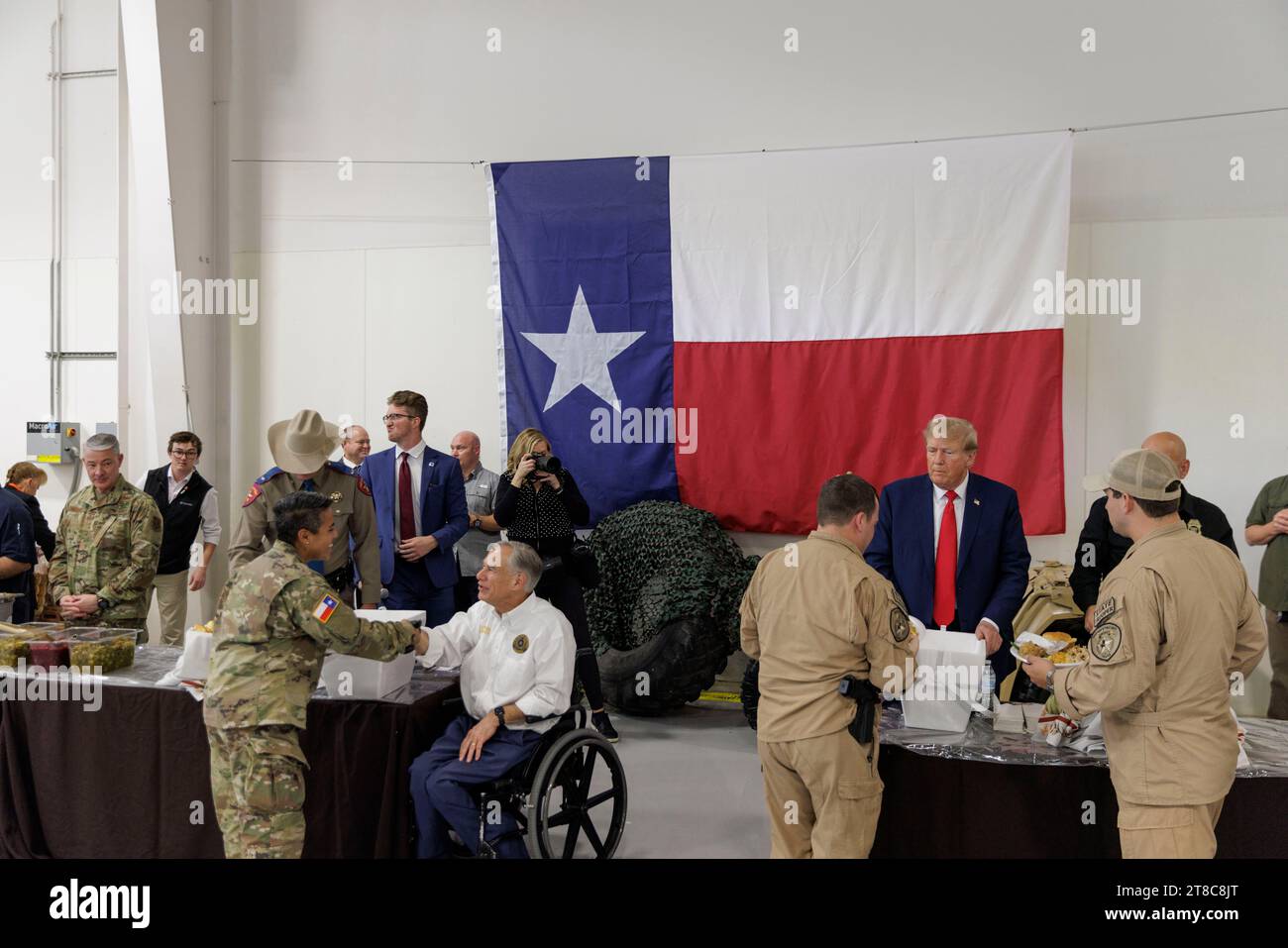 Edinburg, Texas USA, November 19 2023:. Former President DONALD TRUMP and Texas Governor GREG ABBOTT help serve an early holiday meal to Texas Department of Public Safety (DPS) troopers and Texas National Guard members stationed at the U.S.-Mexico border over the Thanksgiving holiday. Photo by Michael Gonzalez/Pool Stock Photo