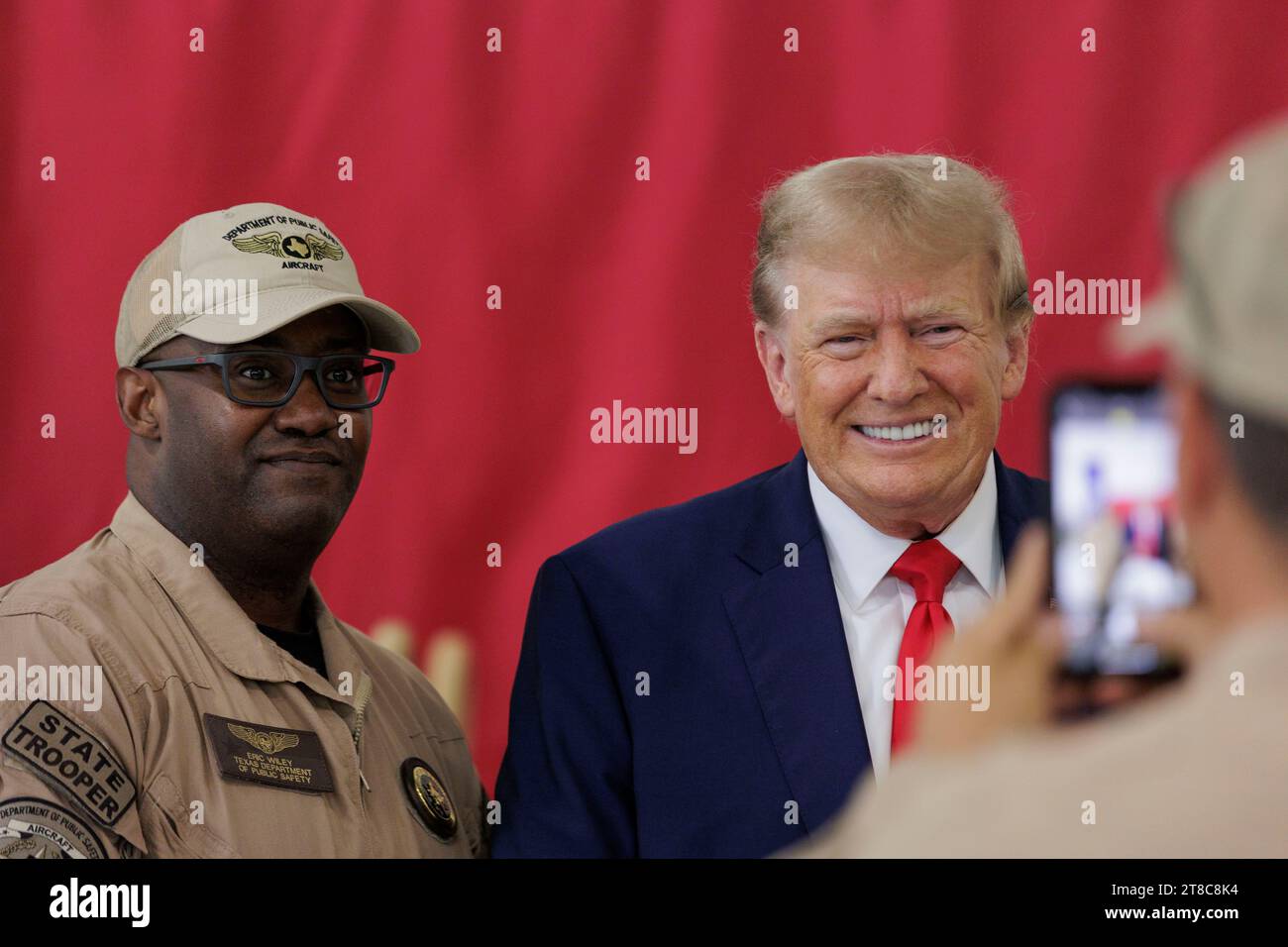Edinburg, Texas USA, November 19 2023: Former President DONALD TRUMP, a candidate for the Republican presidential nomination, poses for a photo with a member of the Texas Department of Public Safety at the South Texas International Airport. Trump flew in for a campaign rally at the airport. Photo by Michael Gonzalez/Pool Stock Photo