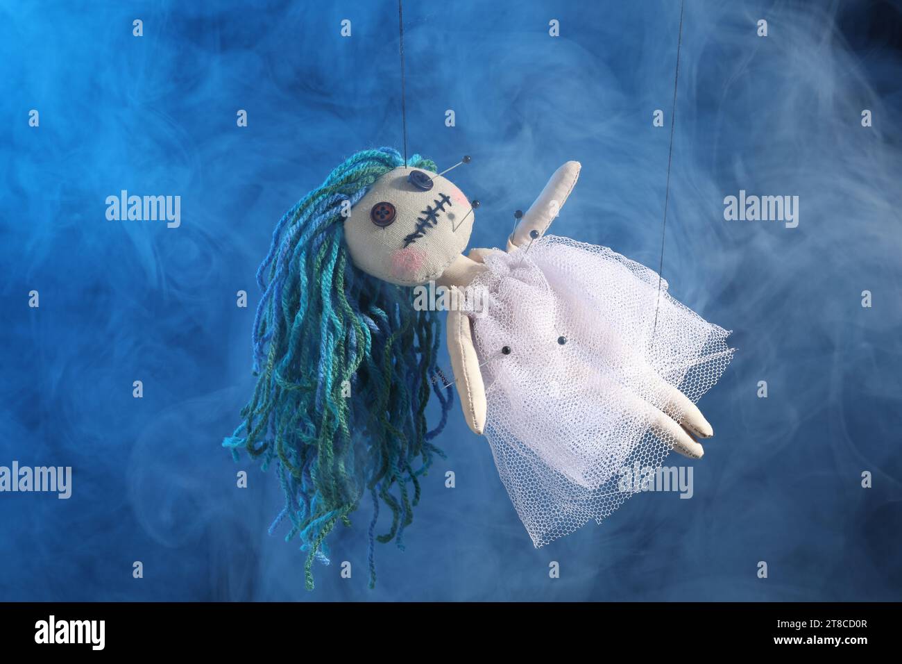 Female voodoo doll with pins and smoke on blue background Stock Photo ...