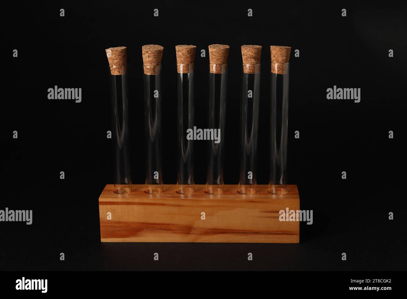 Test tubes in wooden stand on black background. Laboratory glassware ...