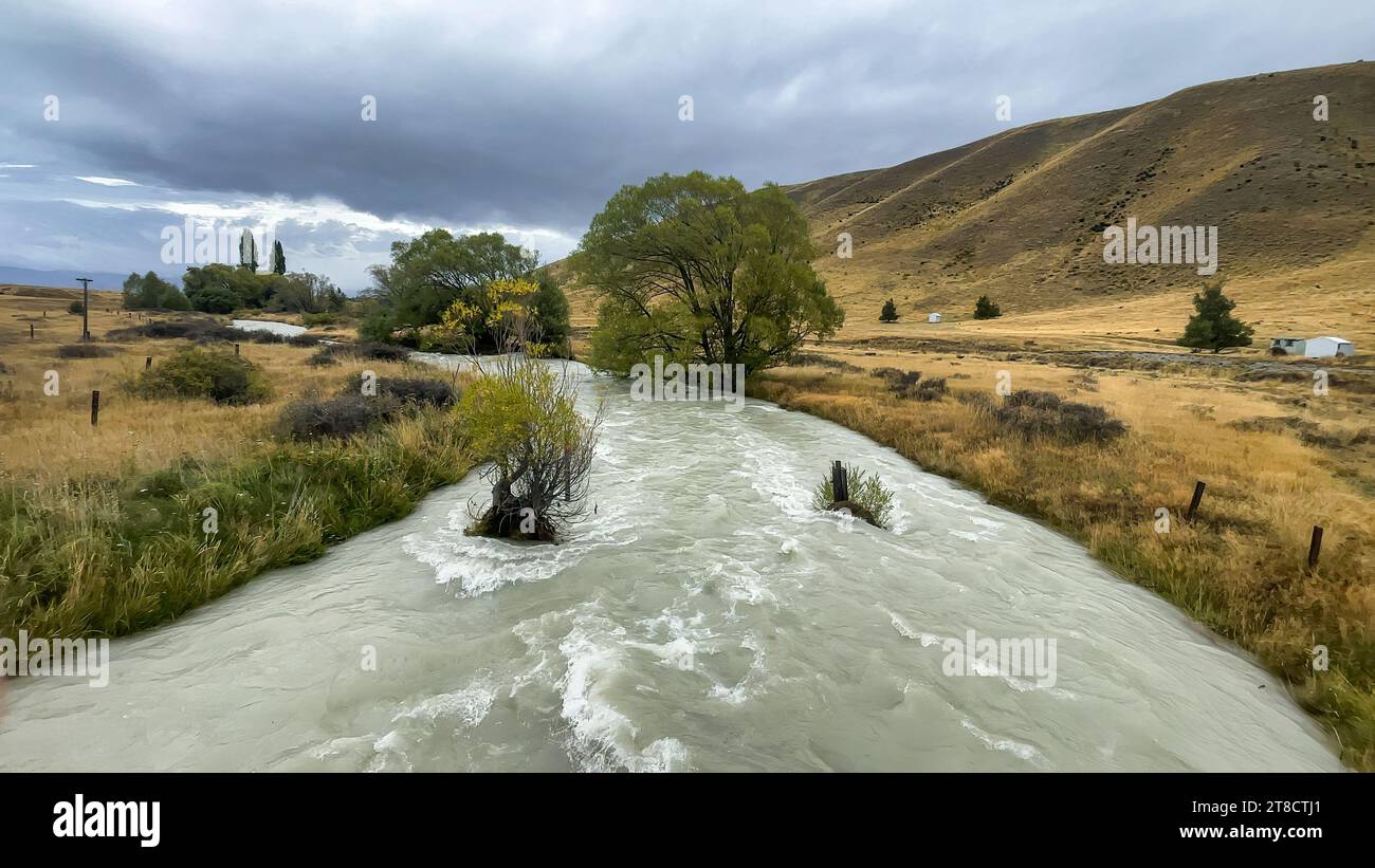 Flooded stream on the winding narrow gravel road between Lake Tekapo ...
