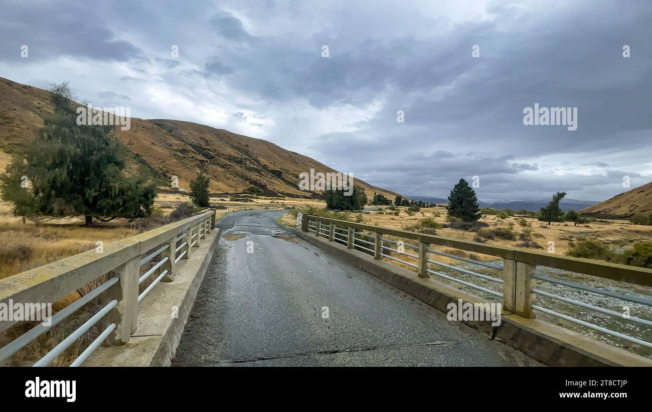 Flooded stream on the winding narrow gravel road between Lake Tekapo ...