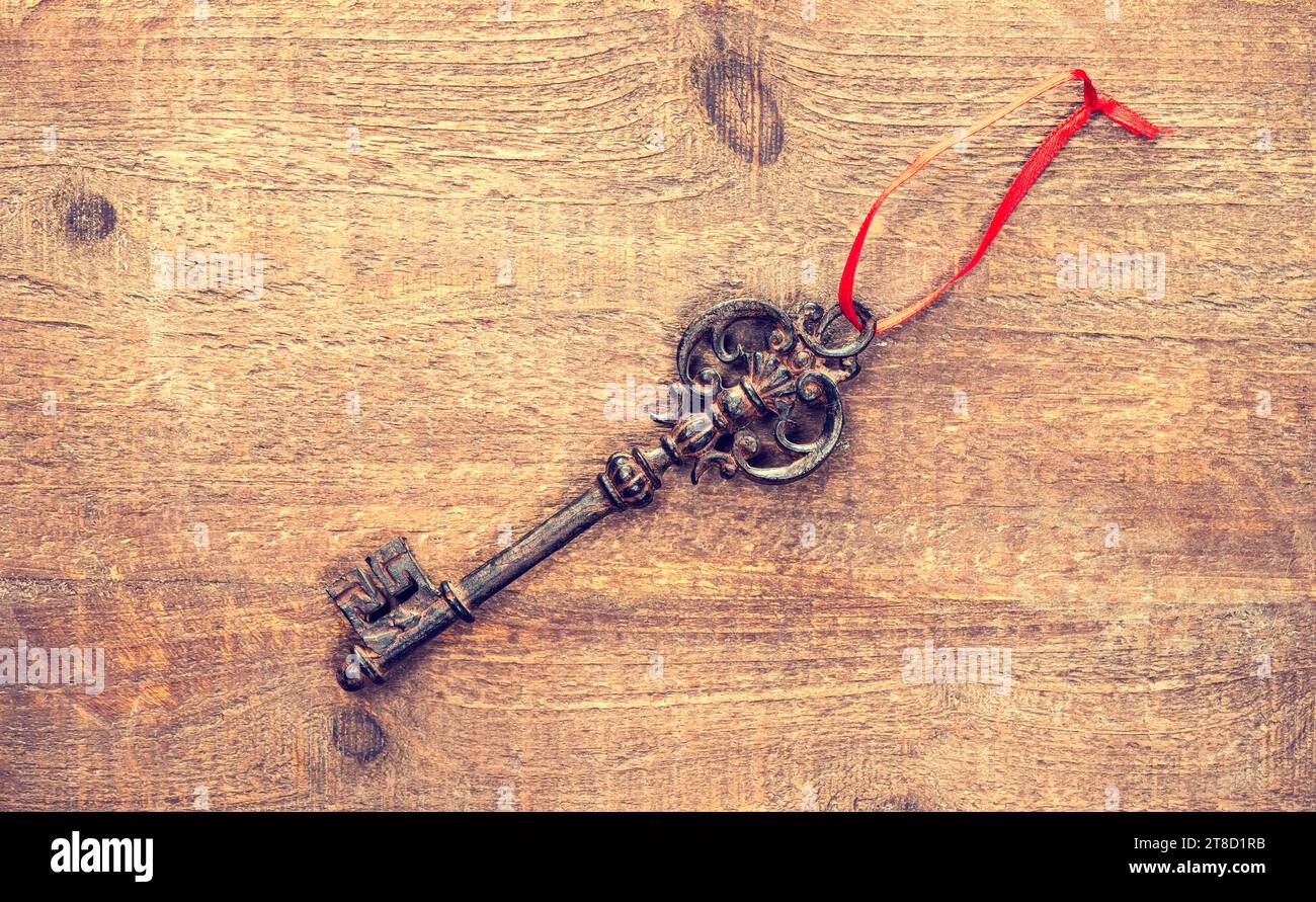 old keys on wooden background with ribbon Stock Photo