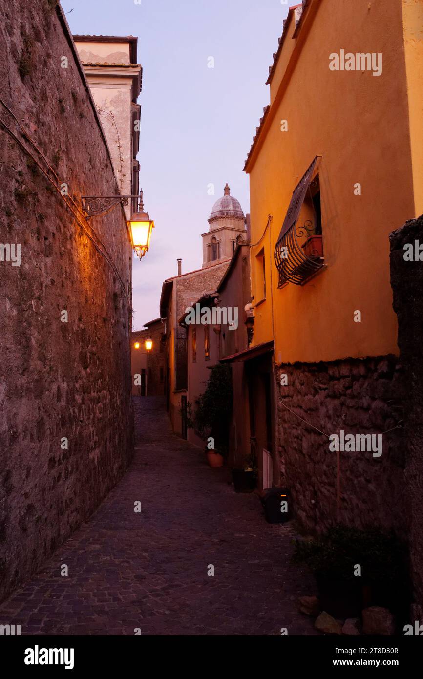 Historic narrow street with streetlamp glowing at dusk in the town of Montefiascone, Lazio Region, Italy. November 19, 2023 Stock Photo