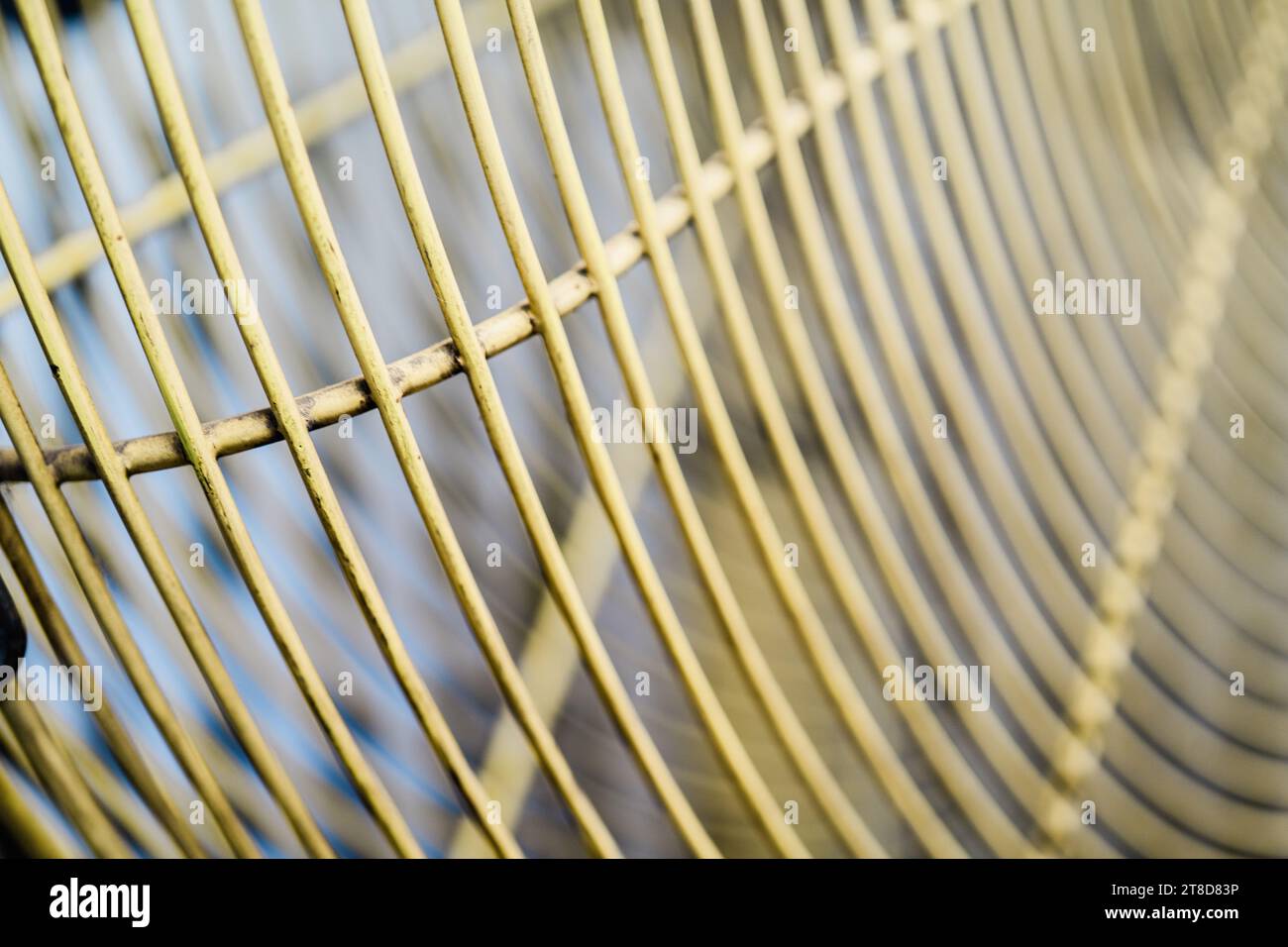A close up image of a golden electric fan with its blades spinning rapidly in motion Stock Photo