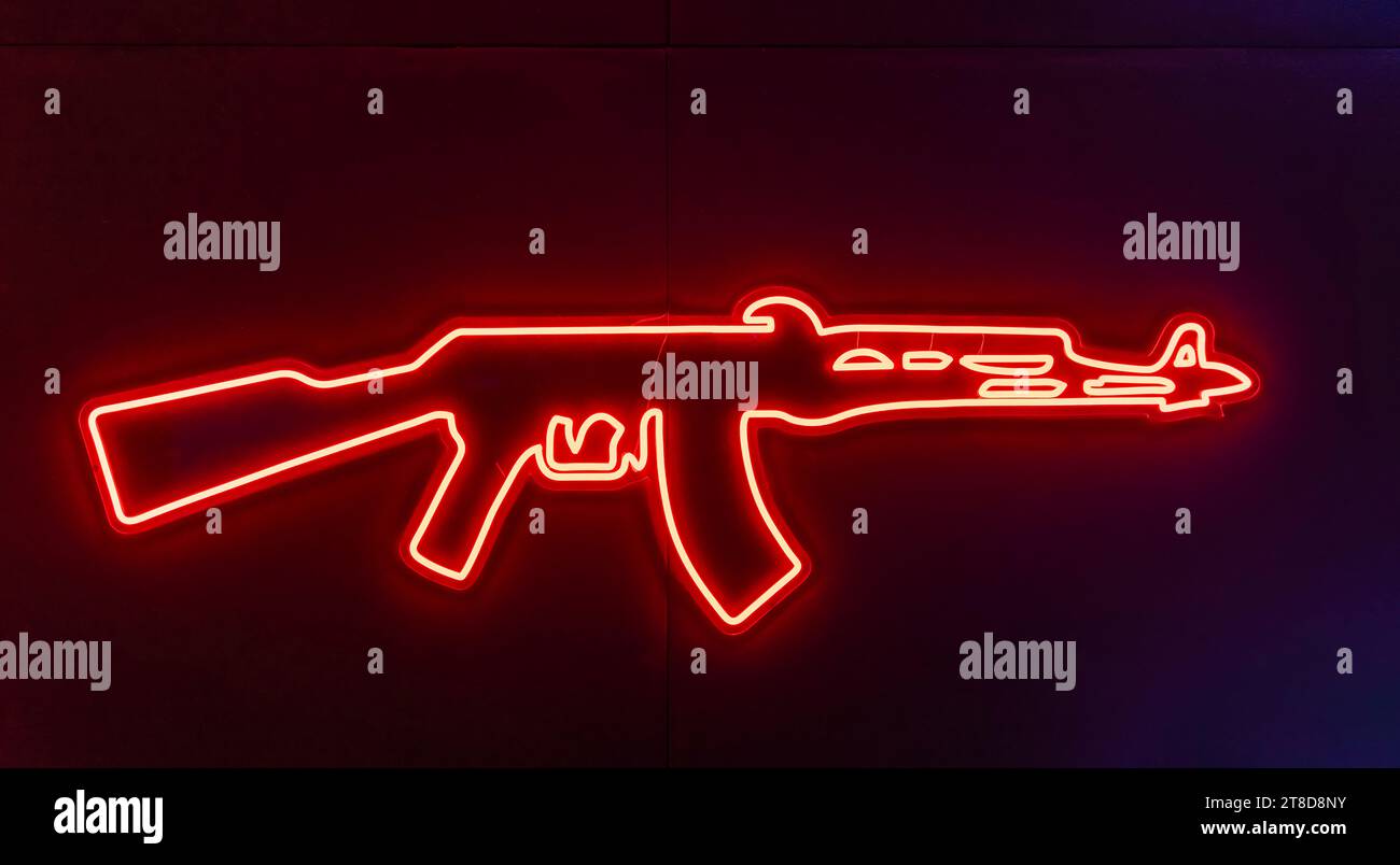 Glowing neon line weapon gun icon isolated on blue background Stock Photo