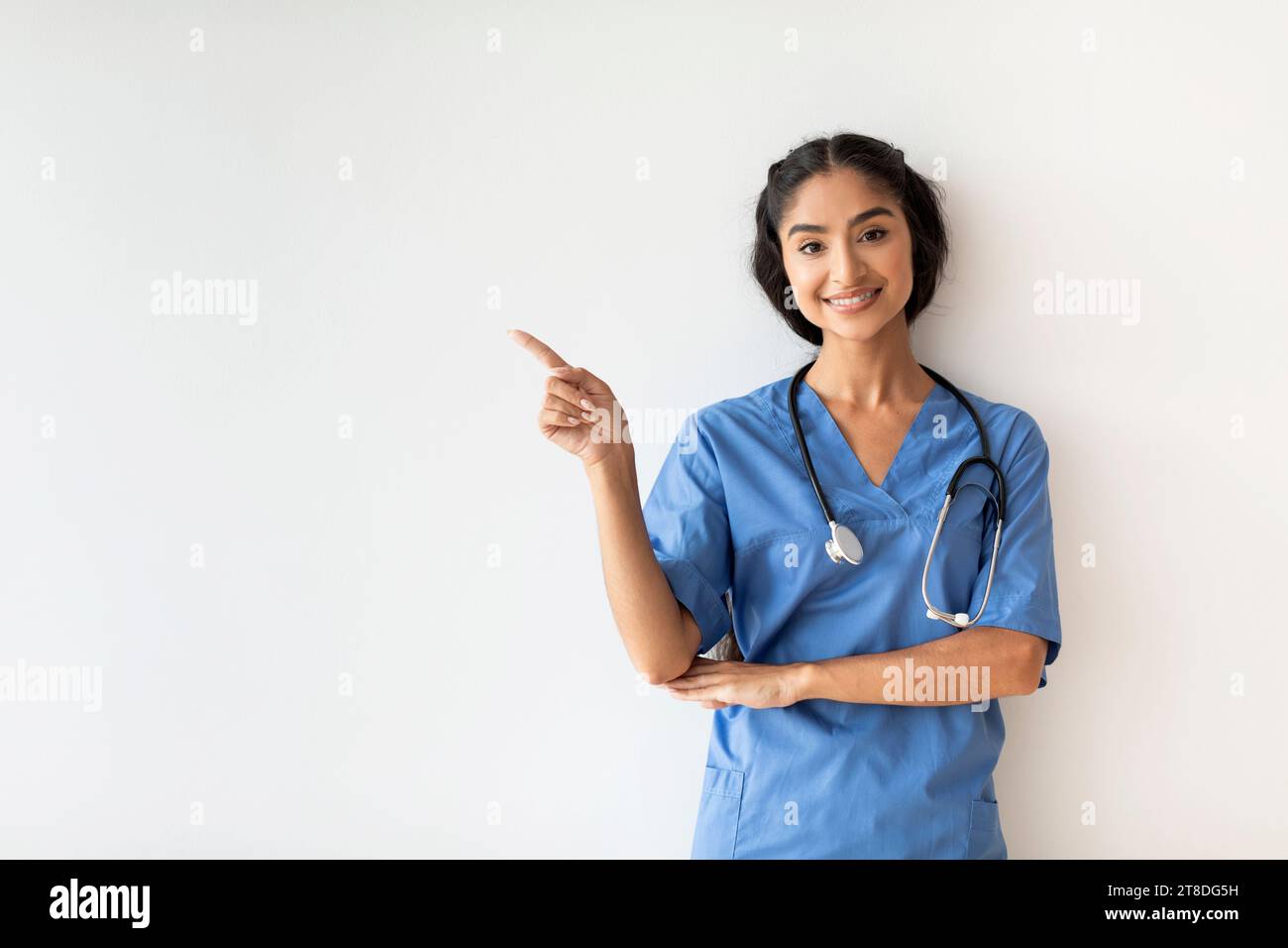 Young Indian Doctor Woman In Blue Uniform Pointing At Copy Space Stock ...