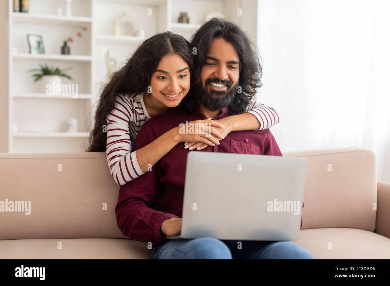 Loving indian spouses shopping on Internet from home, using computer Stock Photo