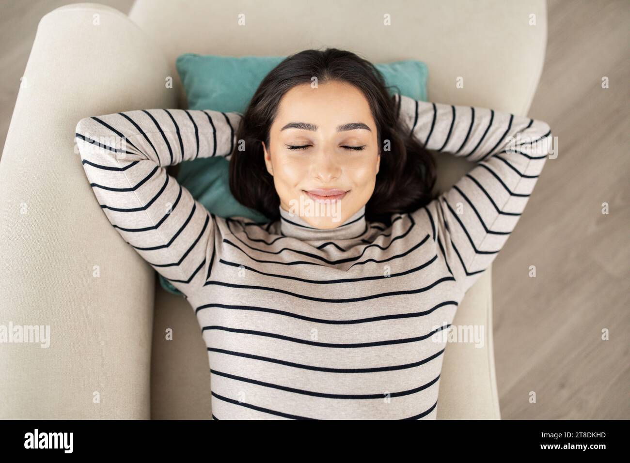 Happy calm young pretty arab woman sleep with closed eyes on sofa Stock Photo