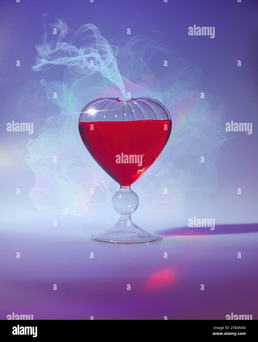 Heart-Shaped Love Potion in Glass Flacon for Romantic Valentine's Day Celebration - Bright and Cheerful Close-Up Shot with Vivid Red and Blue Hues Stock Photo