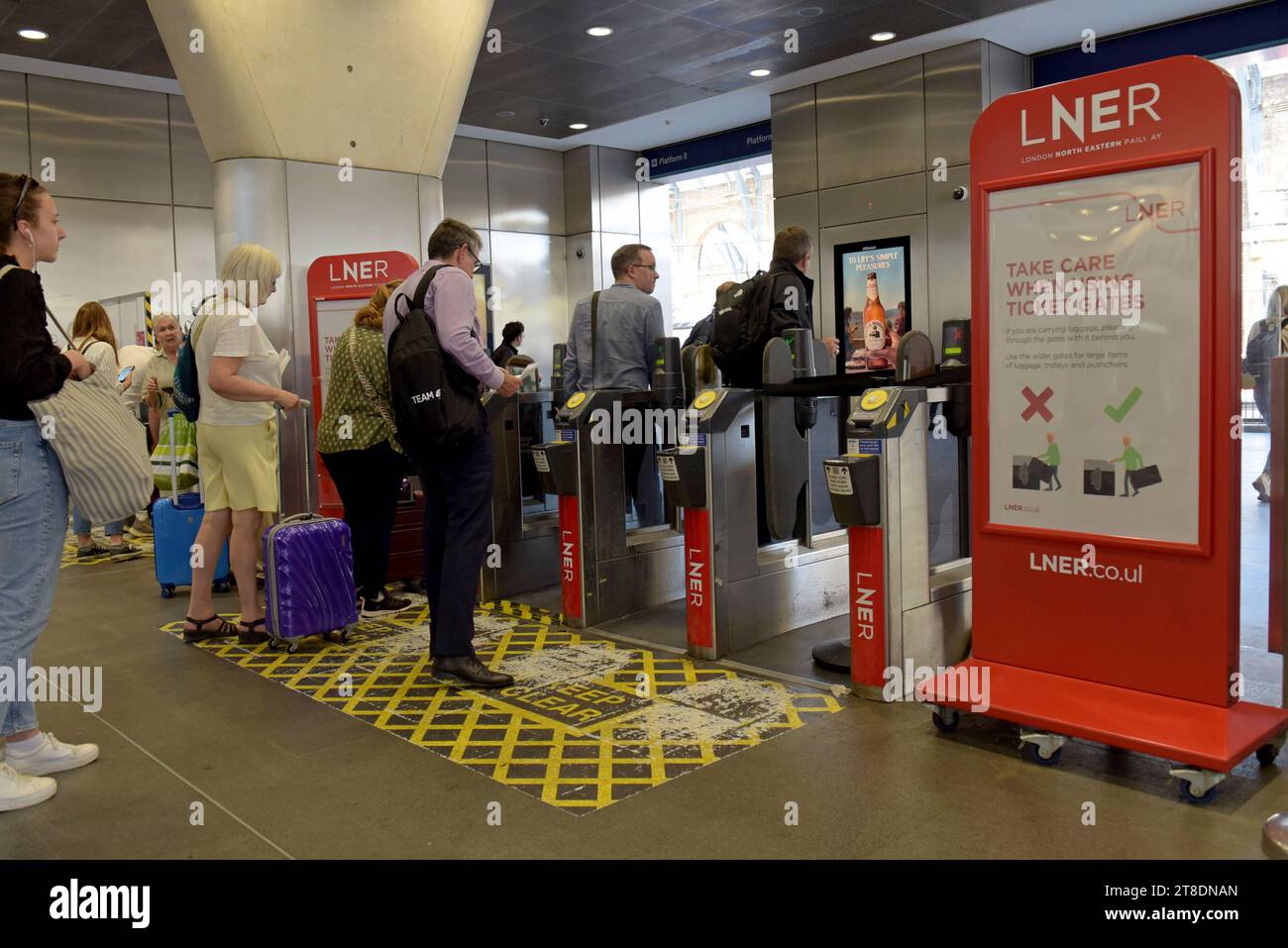 People entering the ticket barriers at Kings Cross Railway Station, London August 2023 Stock