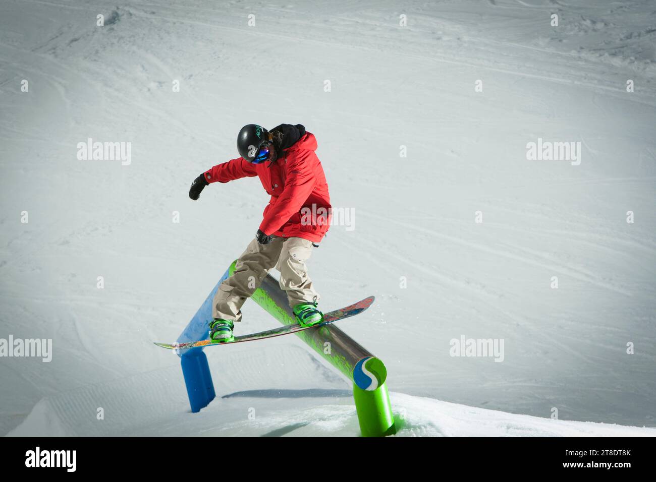 One male snowboarder jibbing a terrain park at a ski resort Stock Photo Alamy