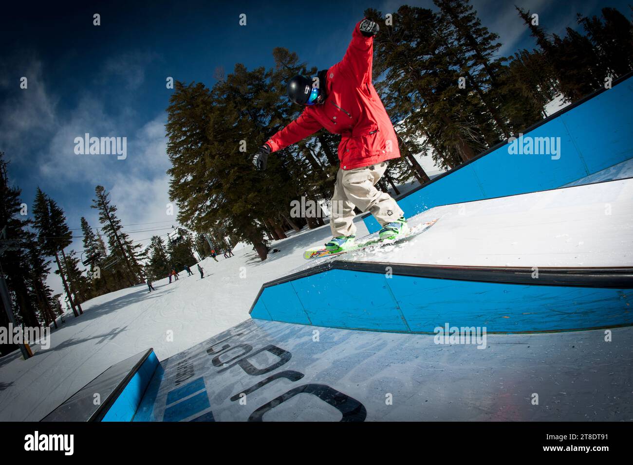 One male snowboarder jibbing a terrain park at a ski resort Stock Photo Alamy
