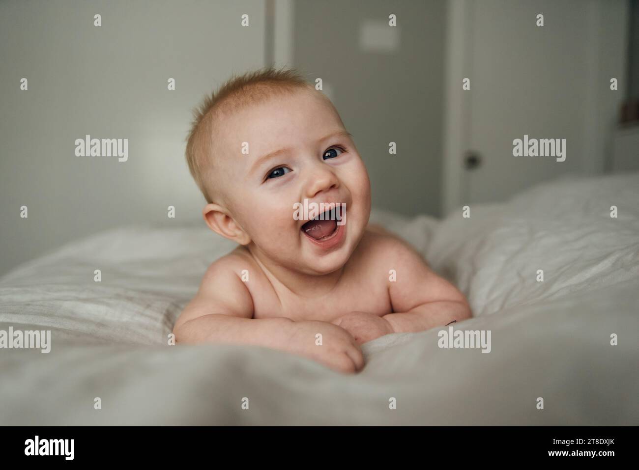 Close up of baby's face smiling widely and laughing at camera on Stock Photo