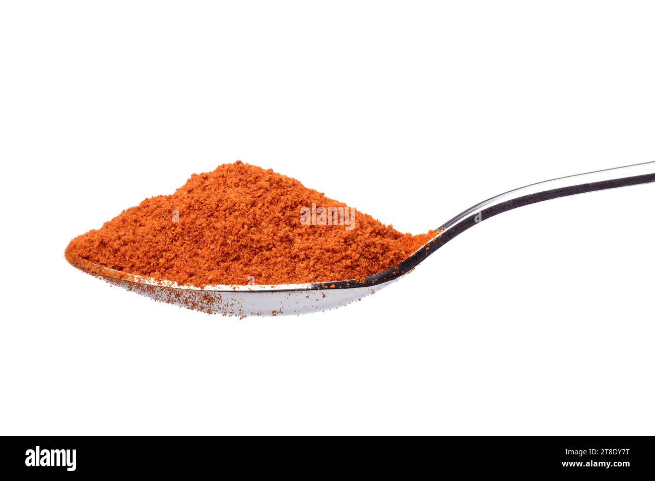 Single metal spoon with ground red pepper paprika powder on white background close up Stock Photo