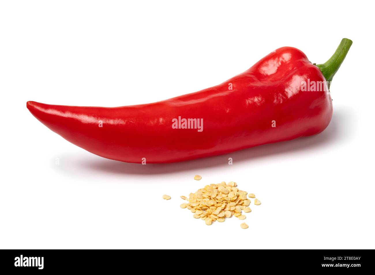 Fresh red pointed bell pepper and a heap of seed in front isolated on white background close up Stock Photo