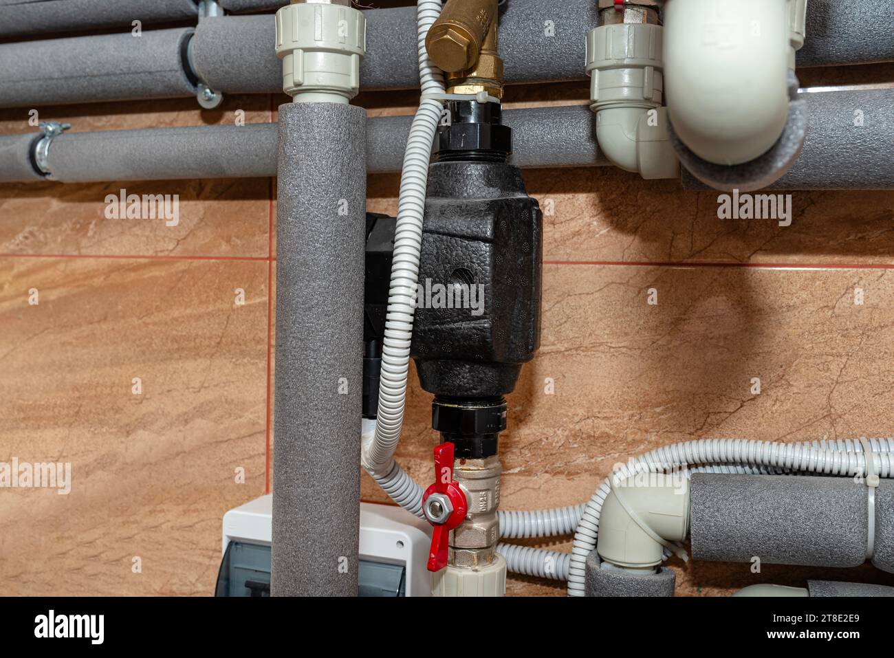 Circulation pump for domestic water installed in a modern heat pump installation in the boiler room. Stock Photo