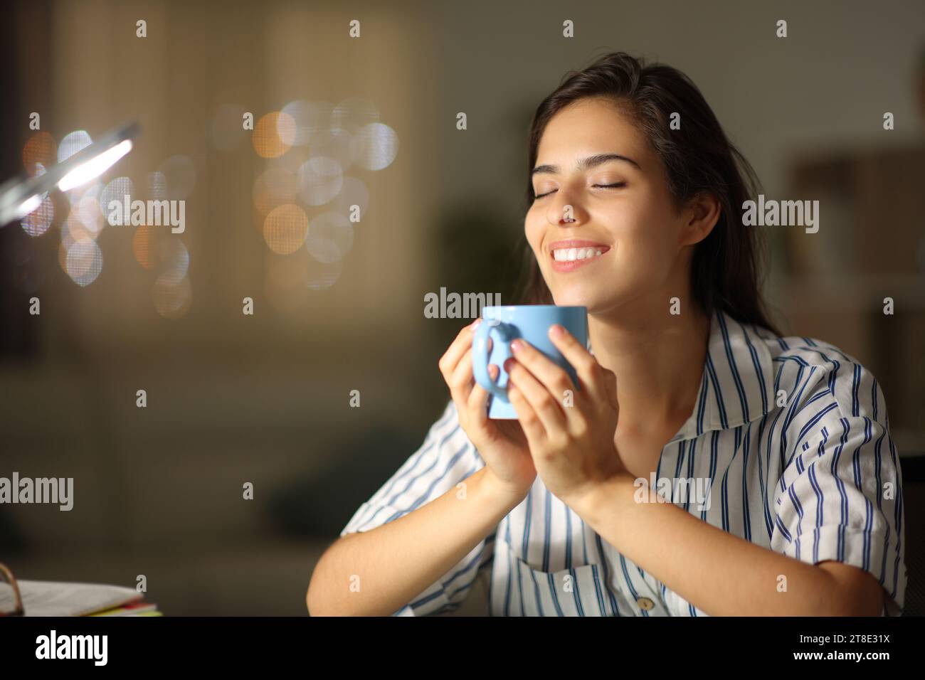Happy woman drinking tea and breathing in the night at home Stock Photo