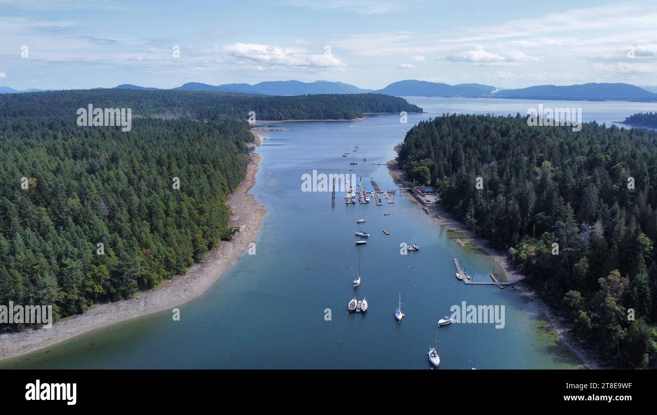 Sailing boat, motorboats, dock and little island. Little harbour from the top. Aerial point of view. Dron view Stock Photo