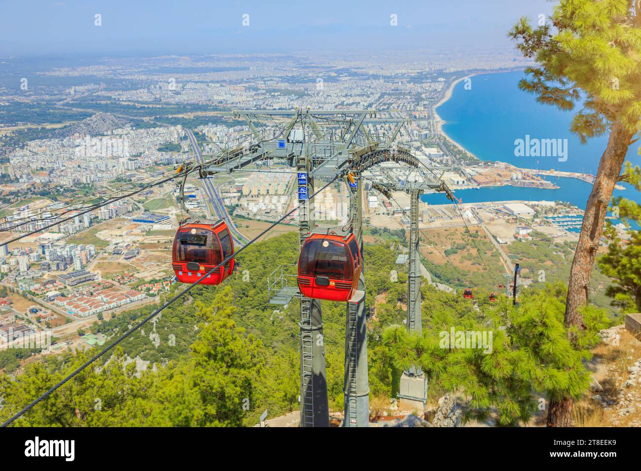 In the picturesque scenery of Antalya, Turkey, a dynamic red cable car gracefully ascends. Against the backdrop of Tunektepe mountain peak, soaring Stock Photo