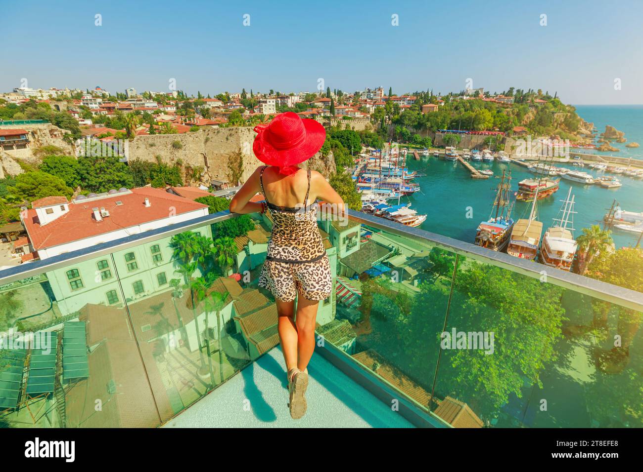 high-angle shot captures a woman joy looking Anatalya panorama and the stunning natural beauty of the sea of Turkey. Stock Photo