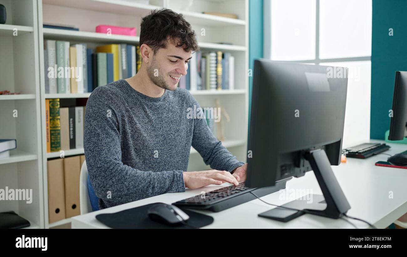 Hispanic Man Using Computer Young hispanic man student using computer smiling at library university ...