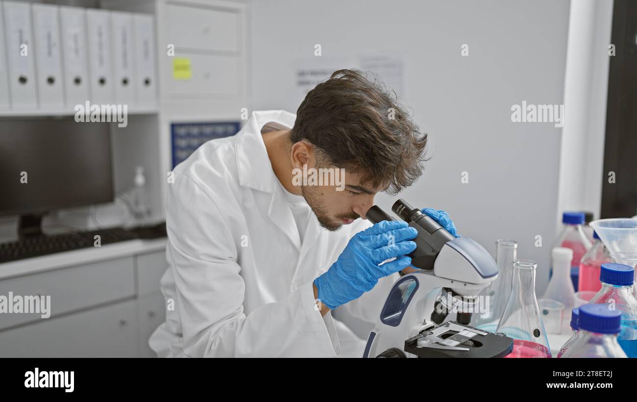 Young arab man scientist using microscope at laboratory Stock Photo