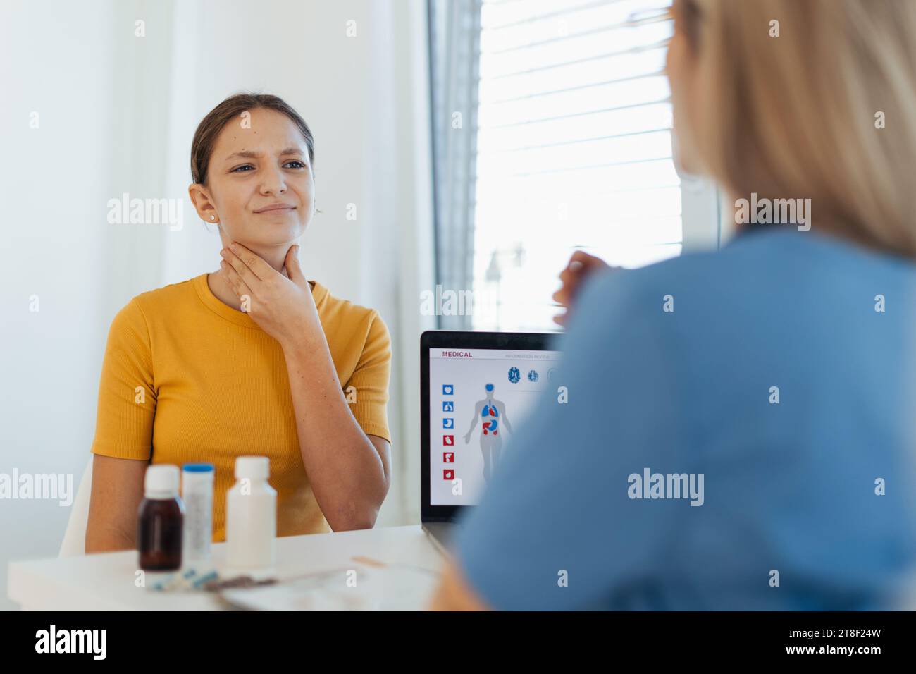 Teenage girl describing her symptoms and pain to the doctor in the