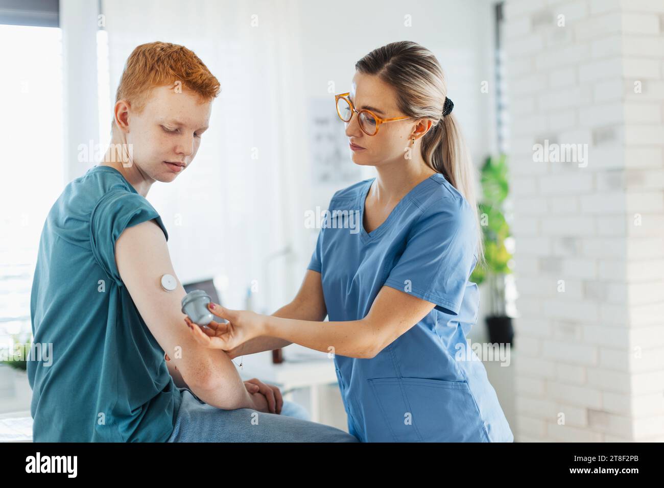 Diabetologist doctor connecting continuous glucose monitor sensor to