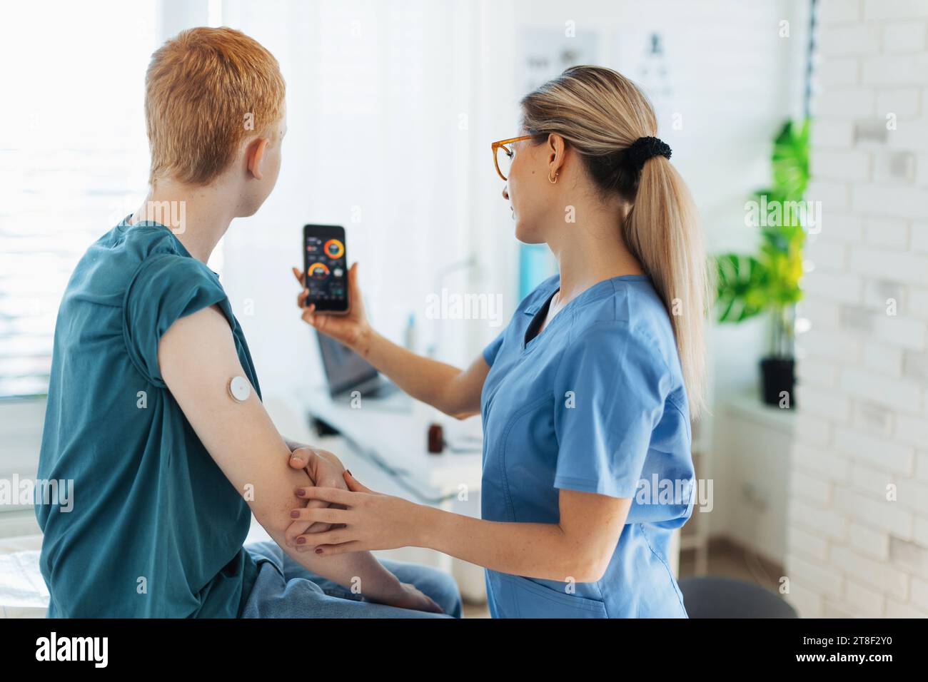 Diabetologist doctor teaching young patient ho to connect continuous