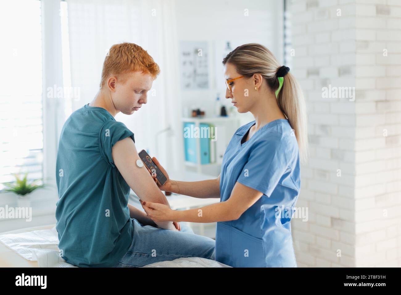 Diabetologist doctor connecting continuous glucose monitor sensor to