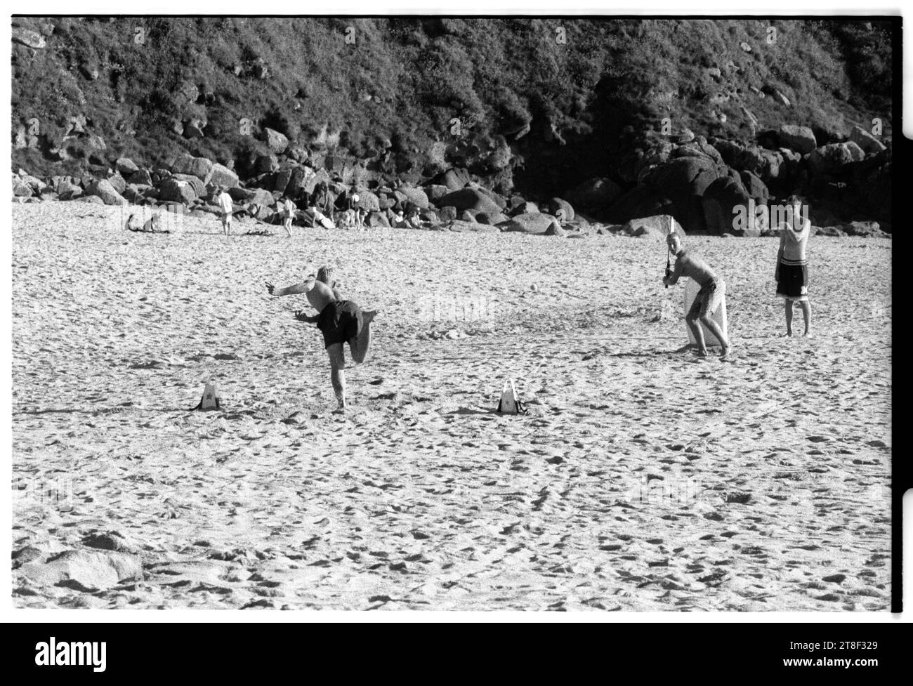 Teenagers play cricket on the beautiful sandy beach at Gwynver Beach at Sennen with a surf board as the stumps in Cornwall, England, August 2000. Picture: ROB WATKINS Stock Photo