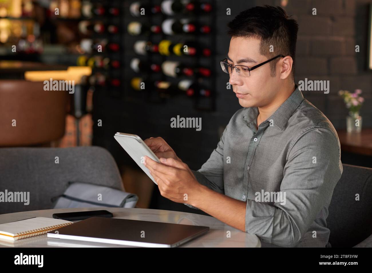 Businessman reading document on digital tablet when working at table in cafe Stock Photo