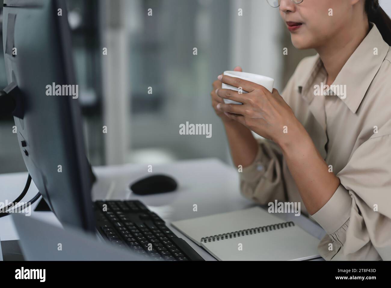 Developer programmer drinking coffee and checking code on monitor for programming to developing web. Stock Photo
