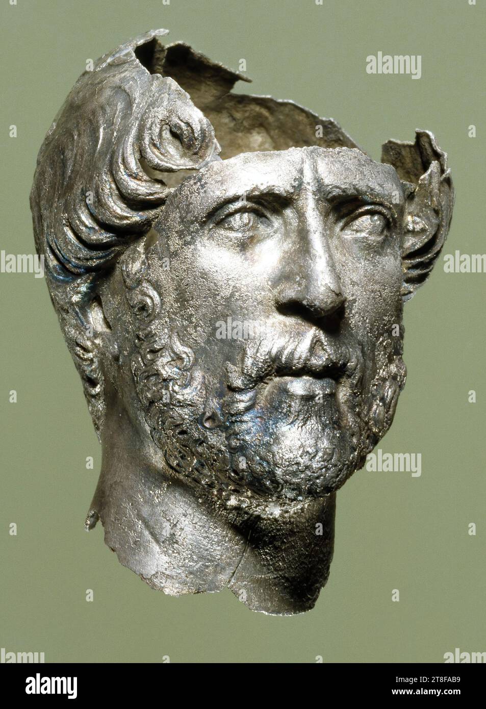 Miniature portrait of a man, 100 - 200, Sculpture, Head, Portrait Head, The small silver head represents a figure with curly hair and a full beard and with eyes looking upwards. The curve of the neck and the modest engraving on the back of the head suggest that it derives from a bust that was originally placed in a circular frame. So it is what is known as a tondo portrait Stock Photo