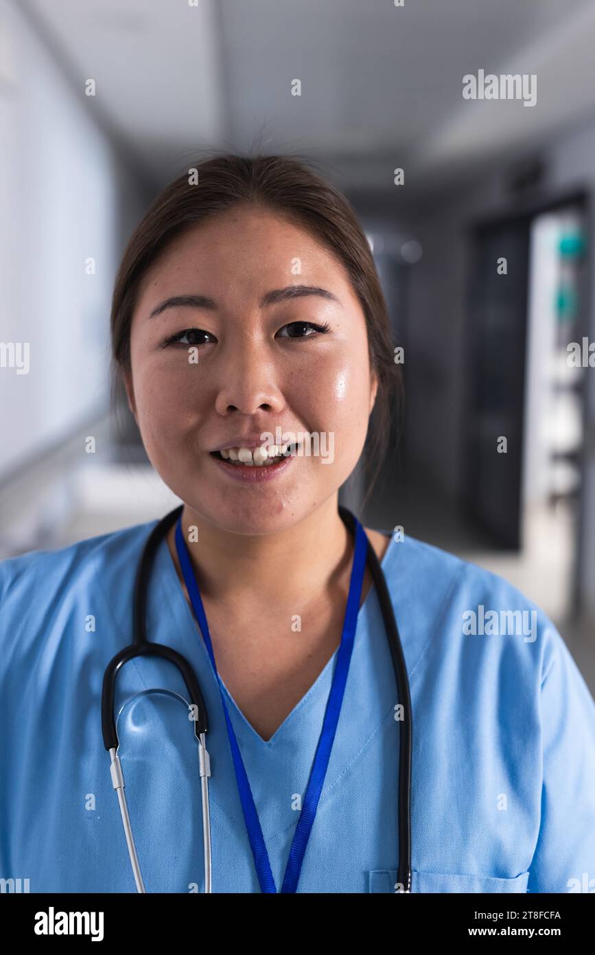 Portrait of happy asian female doctor in hospital corridor Stock Photo