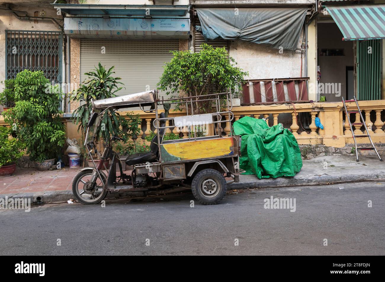 A Tuk Tuk, a form od public transport, parked on the side of a Vietnamese street, in Hanoi Stock Photo